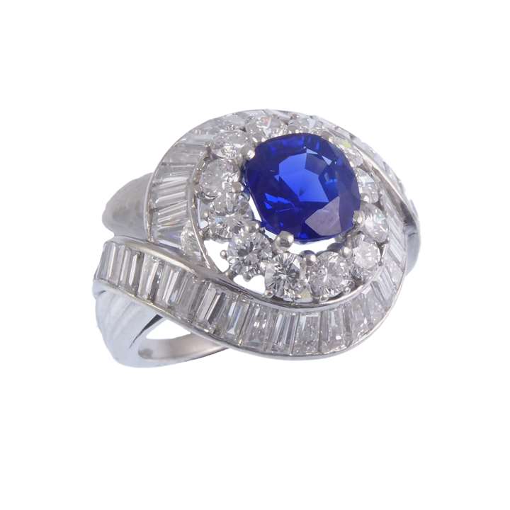 Sapphire and diamond cluster ring, of slightly bombe form, set with a cushion cut Kashmir sapphire of 2.23ct